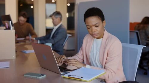 Young Woman Working on Laptop in Modern Office