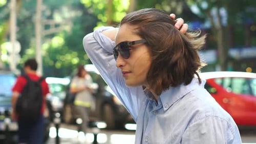 Woman Adjusting Her Hair in Urban Setting