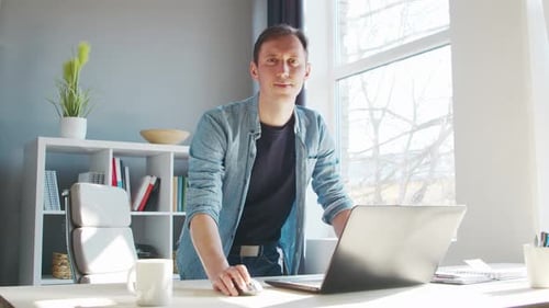Young male entrepreneur works at home office at the computer.