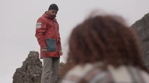 Couple Exploring Rocky Coastline on Overcast Day