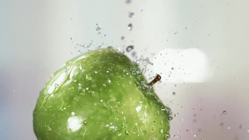 Flying of Green Apple in White Kitchen Background in Slow Motion