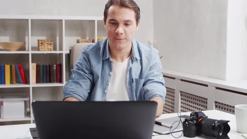 Workplace of freelance worker at home office. Young man works using computer.