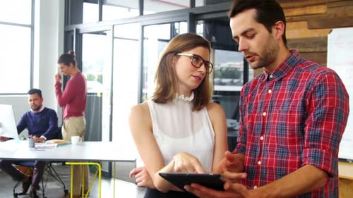 Coworkers Working Together on Tablet in Modern Office