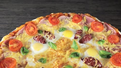 Close-up Pizza with Cheese Tomatoes, Sausage and Egg, Which Revolves Around Itself, View From the