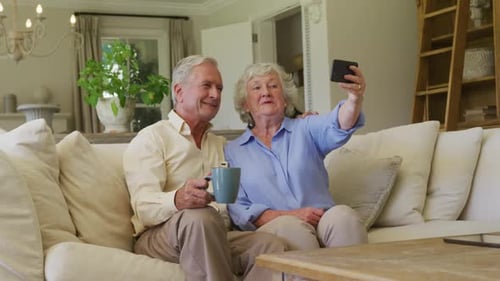 Senior Couple Taking Selfie in Living Room