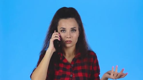 Worried Woman Talking on Phone Against Blue Background