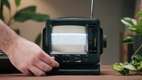 Televisor pequeño y antiguo con pantalla de interferencia gris en el fondo de la casa