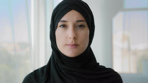 Porträt Ernsthaftes ruhiges arabisches islamisches muslimisches Mädchen im schwarzen Hijab Traditionelles Kopftuch