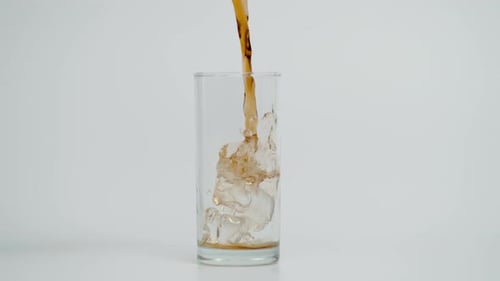 Beverage Being Poured Over Ice in Glass