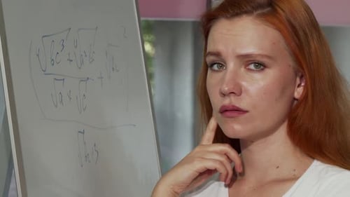Young Red Haired Woman Looking Puzzled While Solving Math Problem