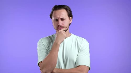 Man Thinking with Hand on Chin Against Purple