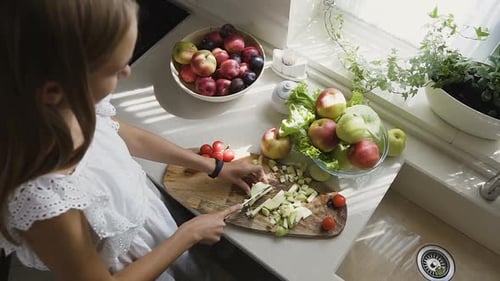 Woman Cutting Apples in Sunny Kitchen