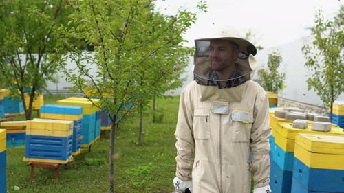 The Beekeeper Walking with Old Bee Smoker on the Apiary
