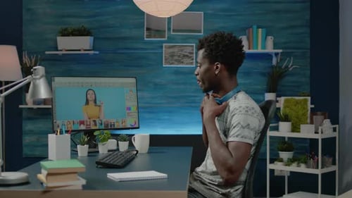 Man Photo Editing at Computer with Headphones