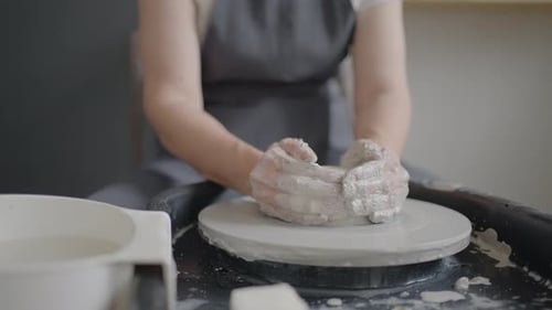 Elderly Woman Master Works on a Potter's Wheel and Makes a Mug of Ceramics in Her Workshop in Slow