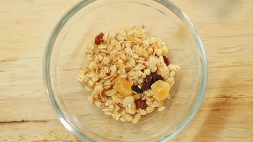 Pouring Cereal and Dried Fruit into Bowl