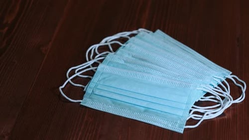 Pile of Surgical Masks on Wooden Surface