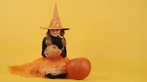 Little Blonde Girl in Witch Costume on Halloween at Orange Studio Background