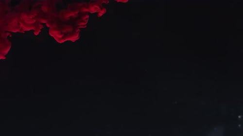 Red Ink Flowing on Black Background