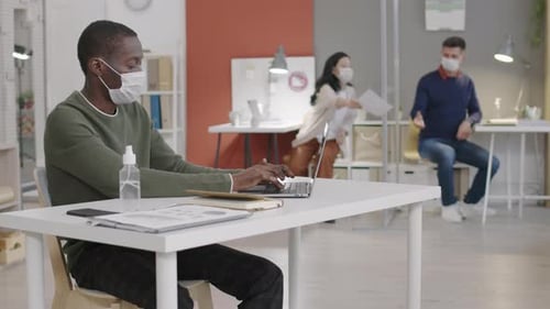 Workers Maintaining Distance Typing on Computers in Office
