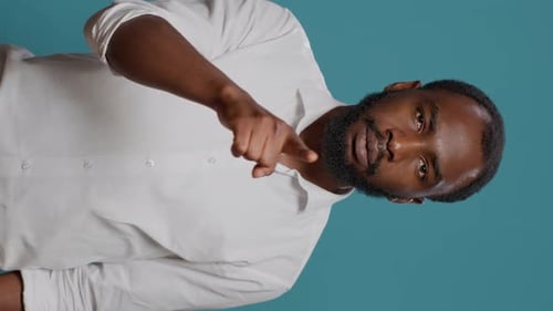 Man Rubs His Nose in a Vertical Studio Shot