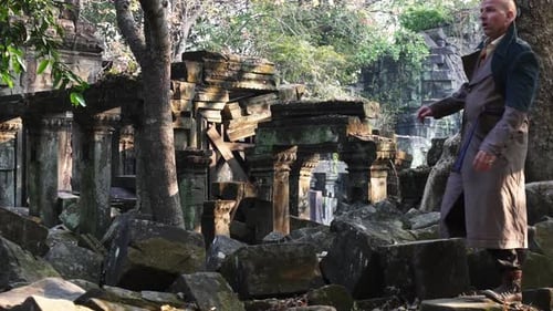 Male Tourist Walking on Top of Piled Up Stones Along the Scenic Temple