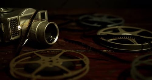 Vintage Camera and Film Reels on Wooden Surface