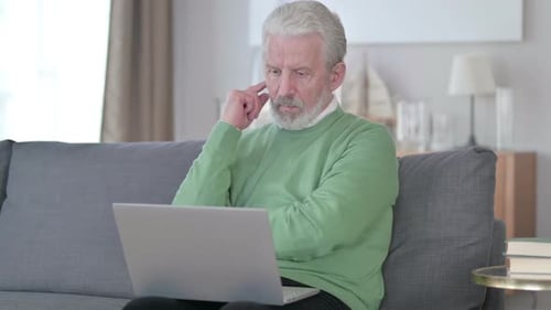 Senior Man Thinking Using Laptop at Home