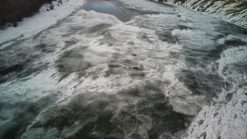 Ruhiger, gefrorener Fluss, der an kalten Wintertagen mit Eis bedeckt ist.