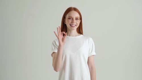Smiling Woman Making OK Sign in Studio