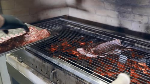El chef cocina grandes trozos de cordero fresco a la parrilla