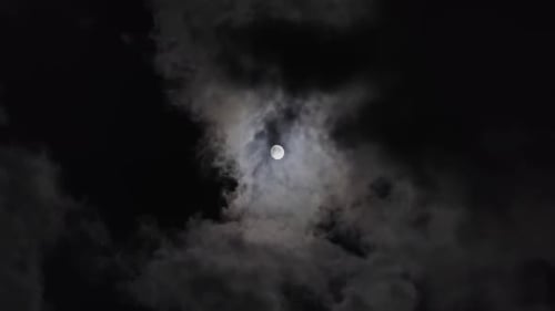 Full Moon Moving Between Clouds
