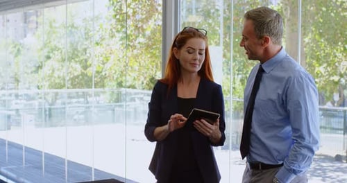 Business Professionals Reviewing Data on Tablet