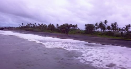 Aerial drone view of a man riding his motocross motorcycle on the beach