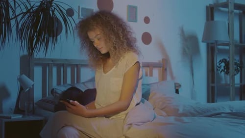 Wife Using Mobile Phone while Husband Sleeping