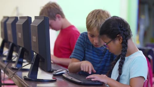 Students in school classroom using computers