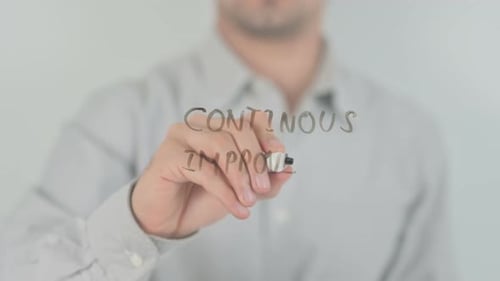 Hand Writes 'Continuous Improvement' with Marker
