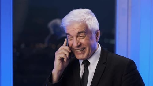 Man in Suit Talking on Smartphone at Night