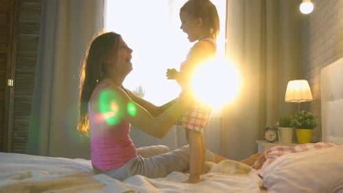 Mom With Daughter At Home On The Bed