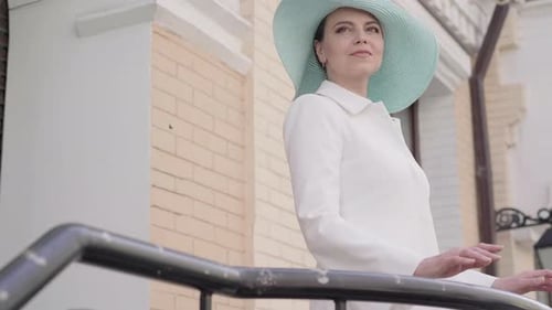 Mid-adult Caucasian Woman Walking To Handrails and Looking Away on City Street. Portrait of Elegant