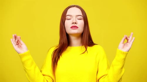 Woman Meditating With Eyes Closed in Yellow Sweater