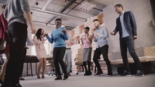 Empresários multiétnicos comemoram o sucesso dos negócios na festa de dança casual de formação de equipes no moderno