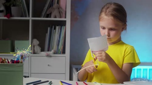 Un enfant avec des ciseaux fait de l'artisanat