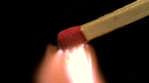 Match Igniting with Bright Flames on Black Background