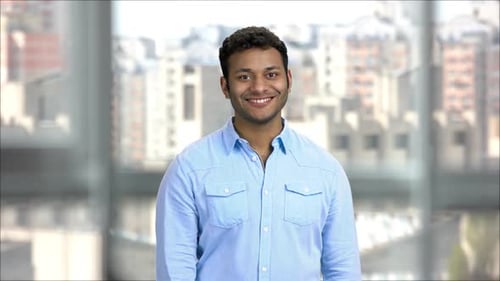 Smiling Man Gives Thumbs Up Gesture Indoors