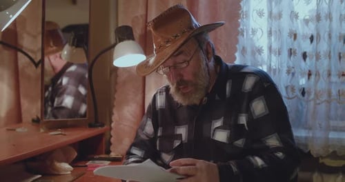 Adult Man Reading Documents in Home Office