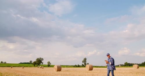 Farmer Using Digital Tablet While Examining Field