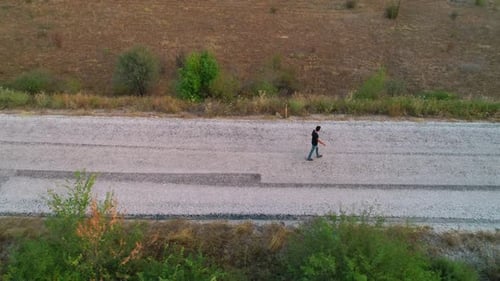 Lonely Young Man Walking On Road