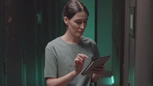 Woman Using Tablet in Dark Data Center