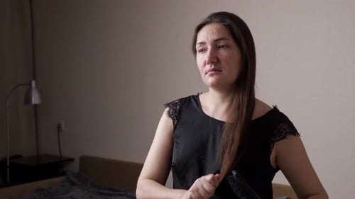 Concentrated Young Woman in Black Tshirt Notices Hair Loss